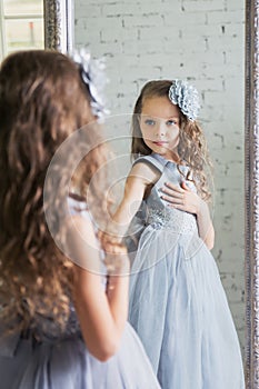 Little girl dresses up front of the mirror
