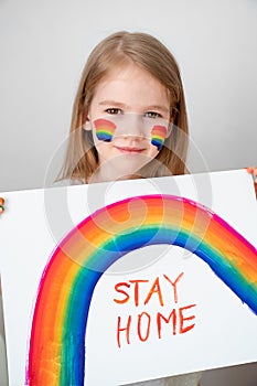 Little girl drew rainbow and poster stay home. photo