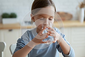 Little girl drink still mineral water feeling thirsty