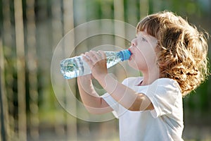 Little girl drinking clean water from plastic