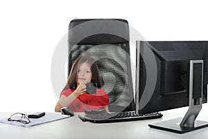 Little girl is drinking coffee in front of a compu
