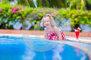 Little girl drinking juice at a swimming pool