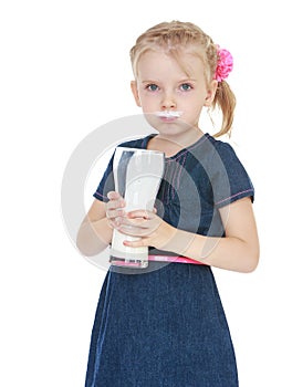 Little girl drinking from a large glass of milk