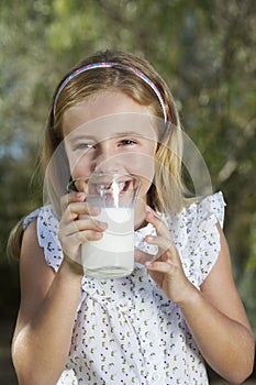 Little Girl Drinking Milk Outdoors