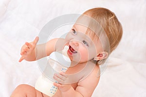 Little girl drinks milk from a bottle. Baby food. concept of artificial feed