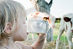 Little girl drinks milk from a glass