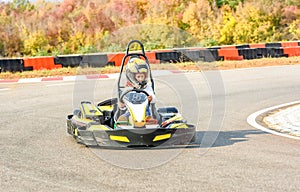 Little girl is driving Go- Kart car in a playground racing track