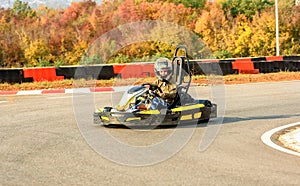 Little girl is driving Go- Kart car in a playground racing track