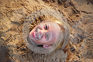 Little girl dug into sand
