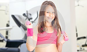 Little girl with dumbbells