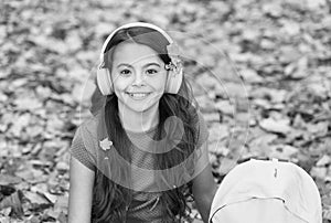 little girl in earpieces with backpack, autumn