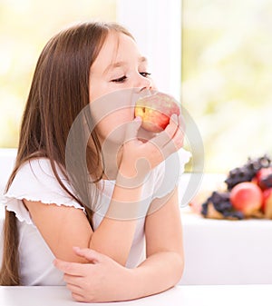 Little girl eating an apple