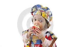 Little girl eating an apple dressed as a chef