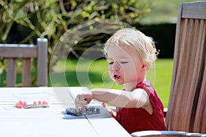 Little girl eating blueberries outdoors