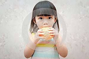 Little girl is eating bread
