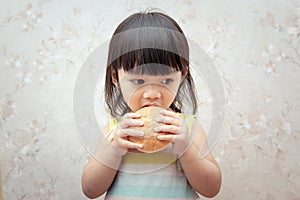 Little girl is eating bread