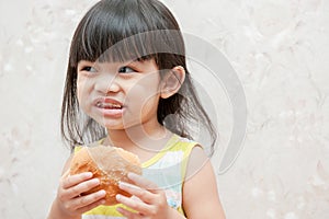 Little girl is eating bread