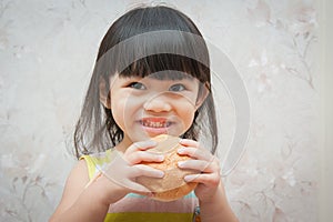Little girl is eating bread