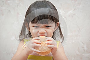 Little girl is eating bread