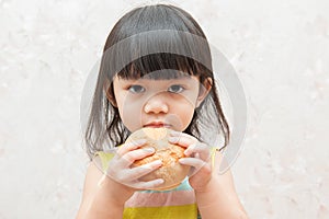 Little girl is eating bread