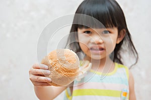 Little girl is eating bread