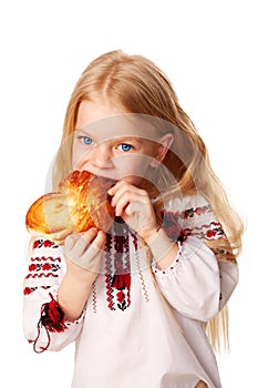 Little girl eating bun with big appetite.