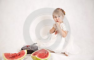 Little girl eating a cake and watermelon