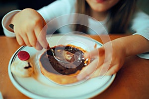 Little Girl Eating a Chocolate Cake in a Restaurant