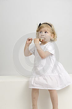 Little girl eating a chocolate lollypop