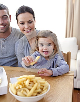 Little girl eating fries at home