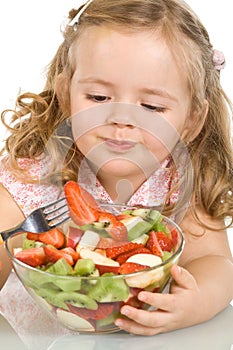 Little girl eating fruit salad