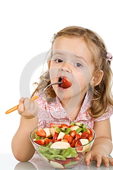 Little girl eating fruit salad