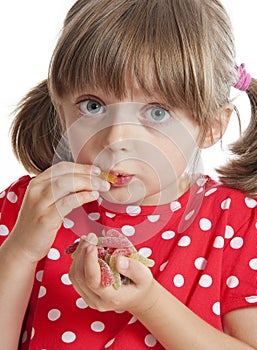 Little girl eating gelatine sweets photo