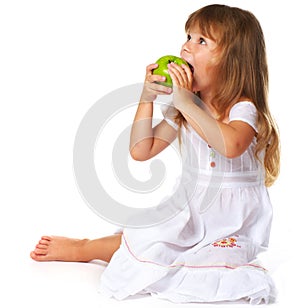 Little girl eating green apple