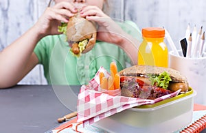 A little girl is eating her lunch at school. Lunch schoolgirl. Toast and and fresh juice and salad for a healthy dinner. Free