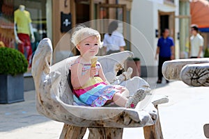 Little girl eating ice cream cone in the city