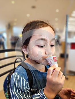 LIttle girl is eating Ice-Cream at the mall. Truly enjoying desserts