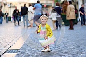 Little girl eating ice cream walking in the city