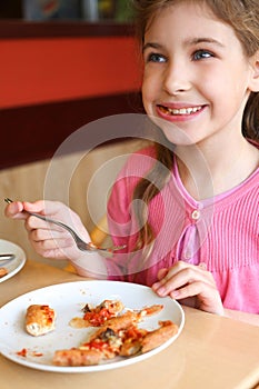 Little girl eating pizza at the