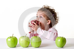 Little girl eating a red apple