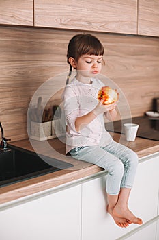 Little girl eating red apple