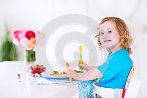 Little girl eating salad for lunch