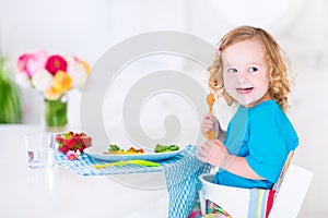 Little girl eating salad for lunch