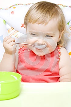 Little girl eating with spoon