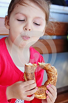 Little girl eating turkish bagel.