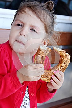 Little girl eating turkish bagel.