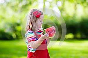 Little girl eating watermelon in the garden