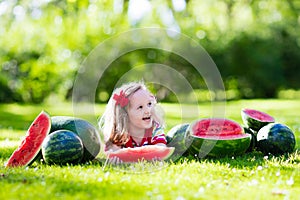 Little girl eating watermelon in the garden