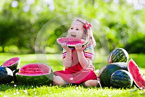 Little girl eating watermelon in the garden