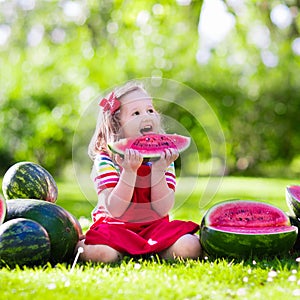 Little girl eating watermelon in the garden